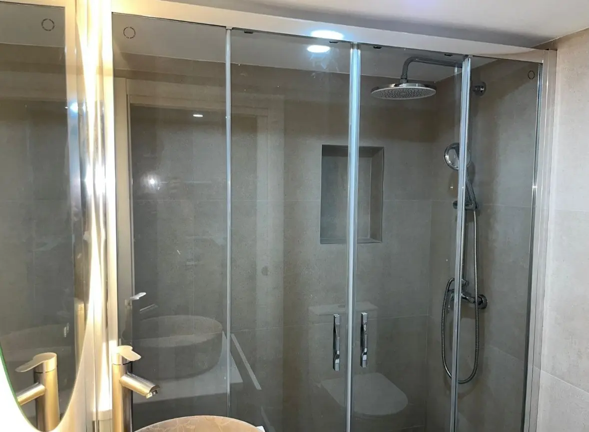 Vista general de la ducha y mampara del baño reformado en Arrabal