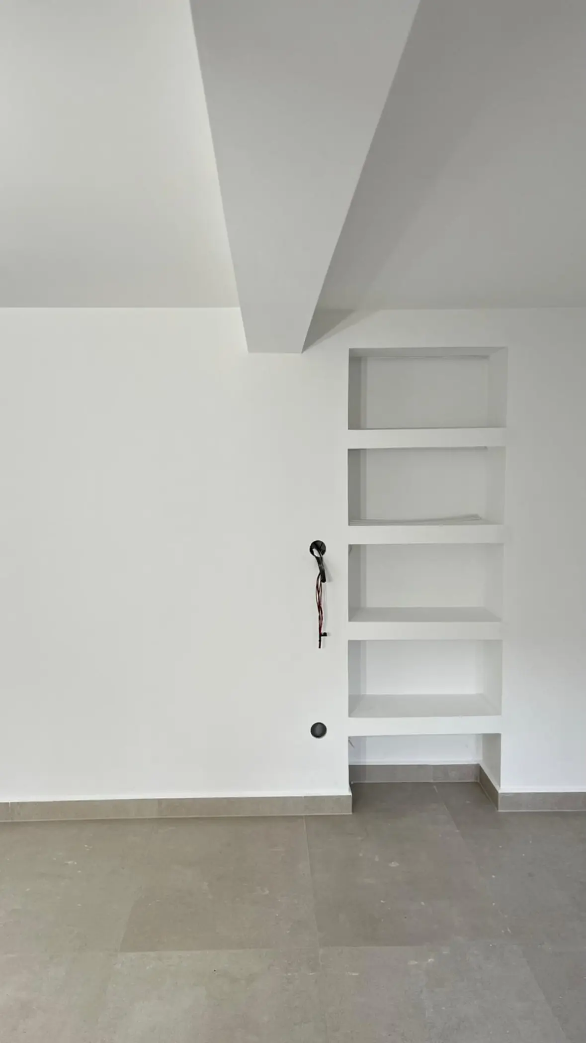 Detalle de hornacinas y pared terminada en la vivienda reformada de Arrabal