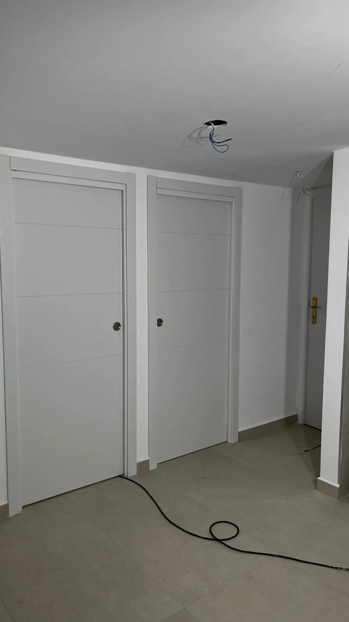 Pasillo y puertas blancas tras la reforma en Arrabal