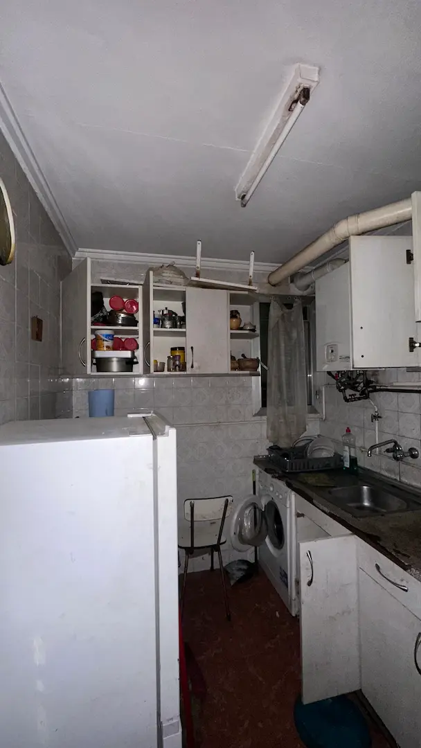 Cocina original antes de la reforma en Delicias con azulejo gris y mobiliario antiguo