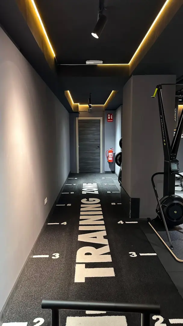 Pasillo interior del gimnasio en Puerta del Carmen con gráfica Training Zone en el suelo